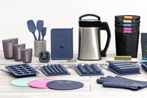 A modern kitchen countertop with the MagicalButter machine surrounded by fresh botanicals, butter, and olive oil, highlighting its ease of use and clean design.