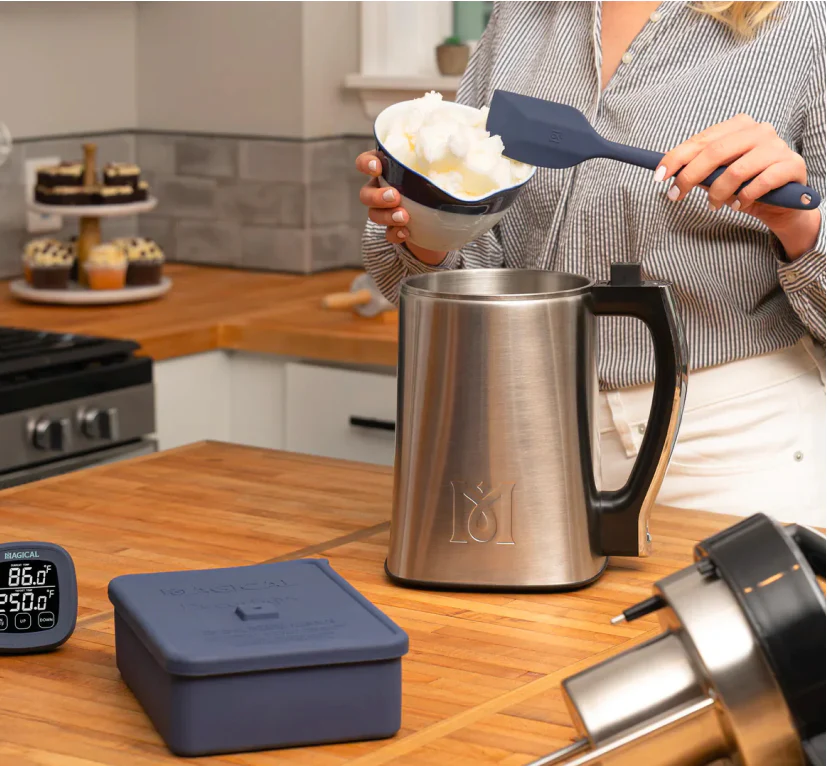 A user is walking away from the MagicalButter machine in a clean, modern kitchen, showing the hands-off operation.